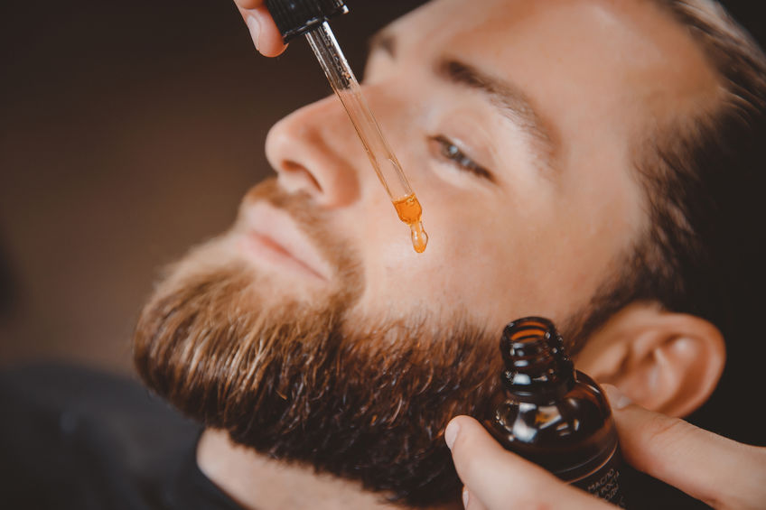 Application d'une huile à barbe sur la barbe d'un homme